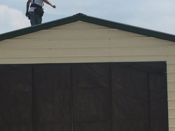 Photo of a crew member standing on top of a commercial garage.