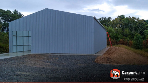 Commercial metal garage building with one roll-up garage door on the side.