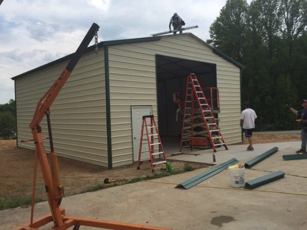 Crew building a commercial metal garage, attaching the trim.