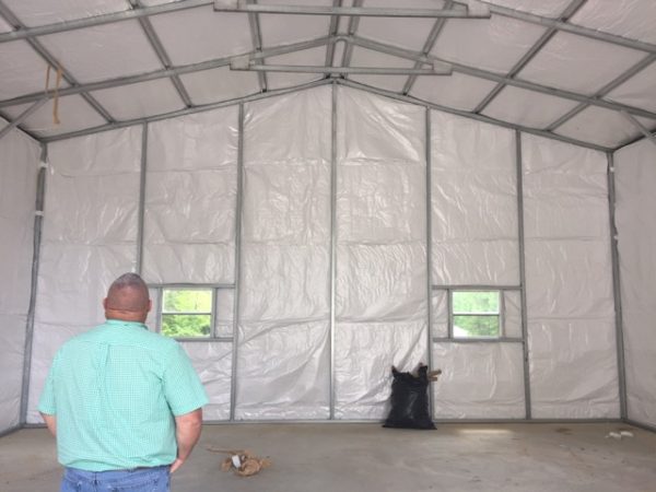 View of the back of a commercial metal garage with two windows and installation.