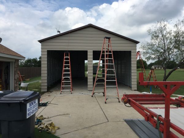Double wide garage with three garage doors not installed yet.