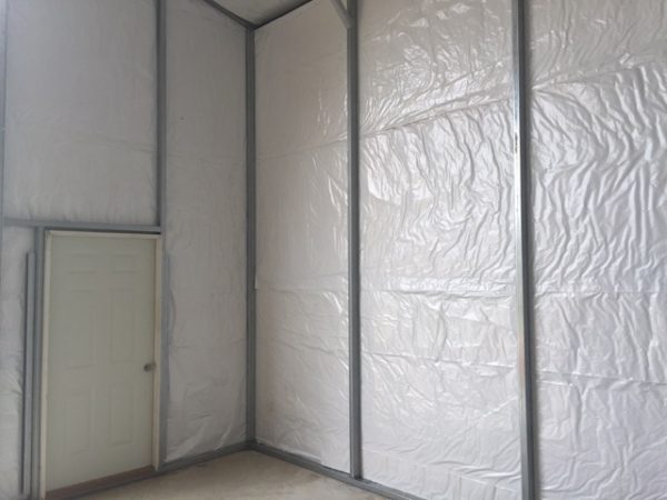 Inside view of commercial metal garage with insulation and man door.