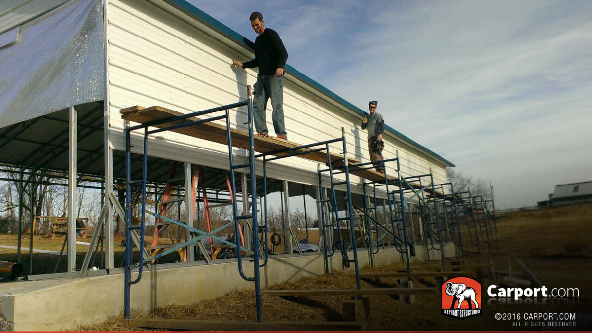 carport-39685556 Crew standing on scaffolding with carport during installation.