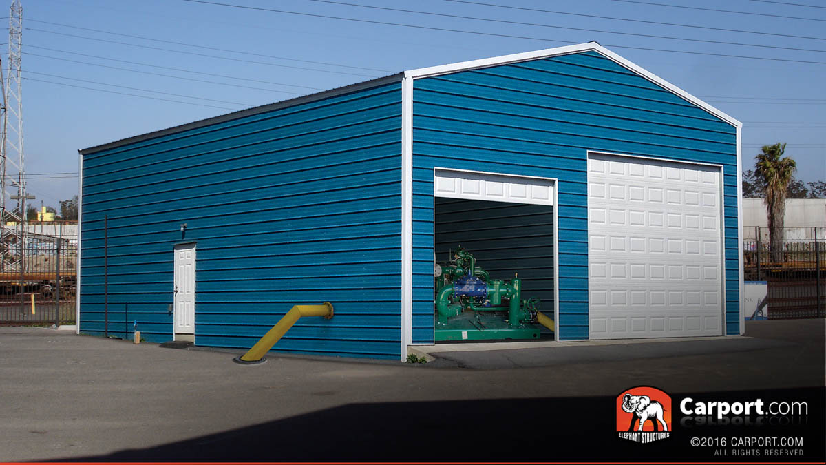 Commercial metal building with two roll up garage doors and water pump inside.