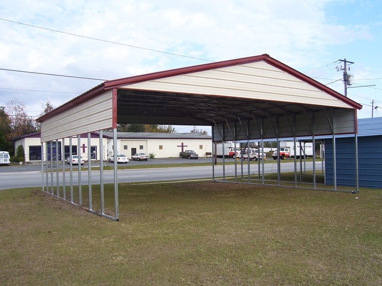 deluxe-double-carport Deluxe double carport with panels hanging on the side, and white gables, red trim.