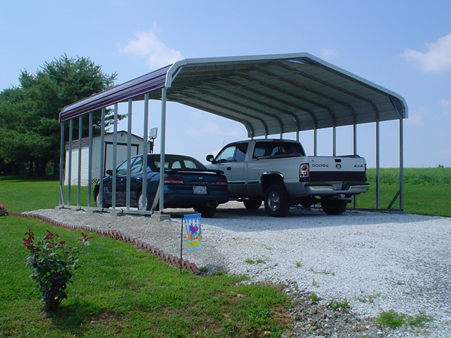 Double carport with red roof and white trim, two cars parked underneath.