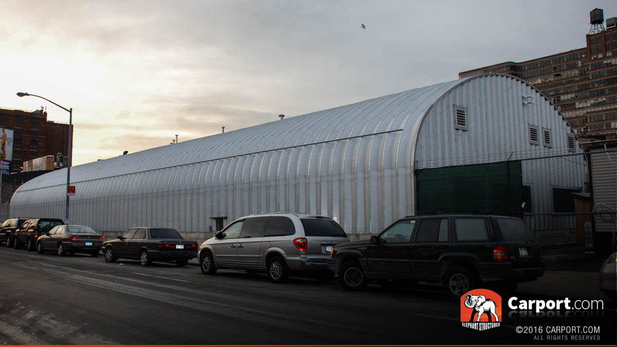 s-model-commercial-steel-arch-2 S model commercial steel arch building with cars parked along the side.