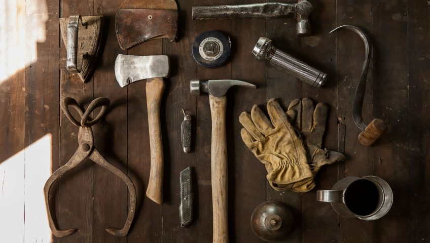 Vintage tools aligned on an old wooden table